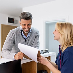 a front desk staff member talking to a patient
