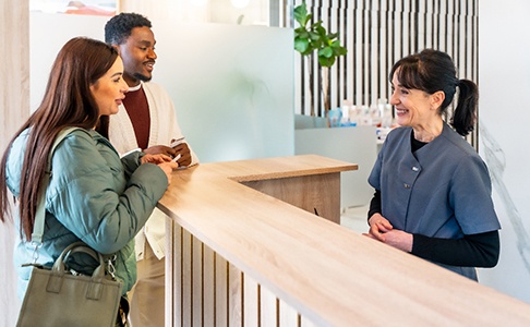 patients speaking with a front desk team member at a dental office